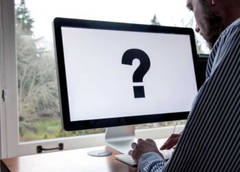 Koje industrije NIS2 najviše pogađa i kako se prilagoditi novim zahtjevima? 2 using computer with large question mark on screen 2025 01 07 22 14 13 utc